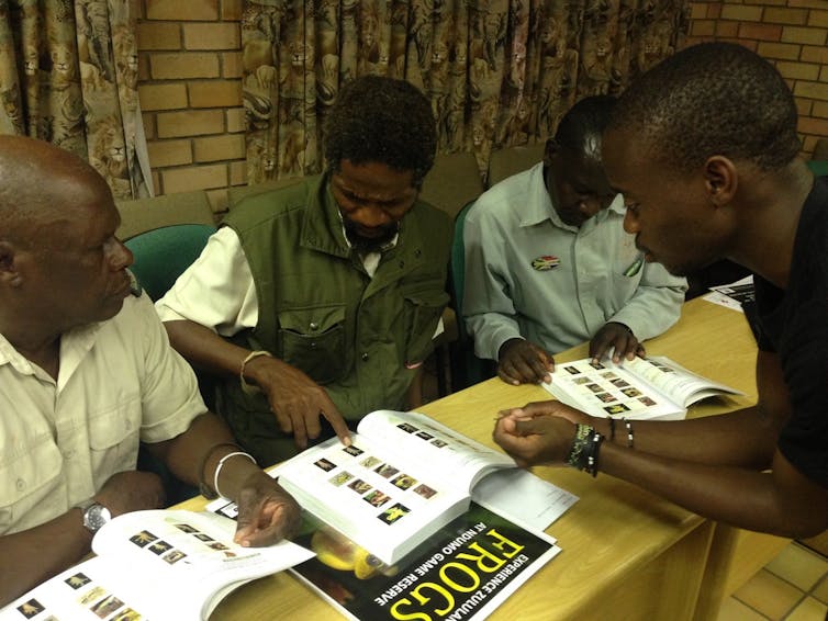 Men looking at photos in books