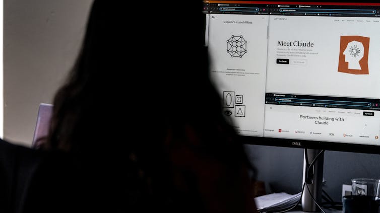 La mujer vista desde atrás, da a la pantalla de la computadora que muestra los elementos de Claude Ai
