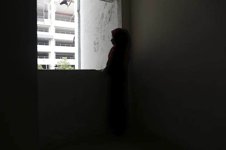 The silhouette of a girl is seen in a darkened room.