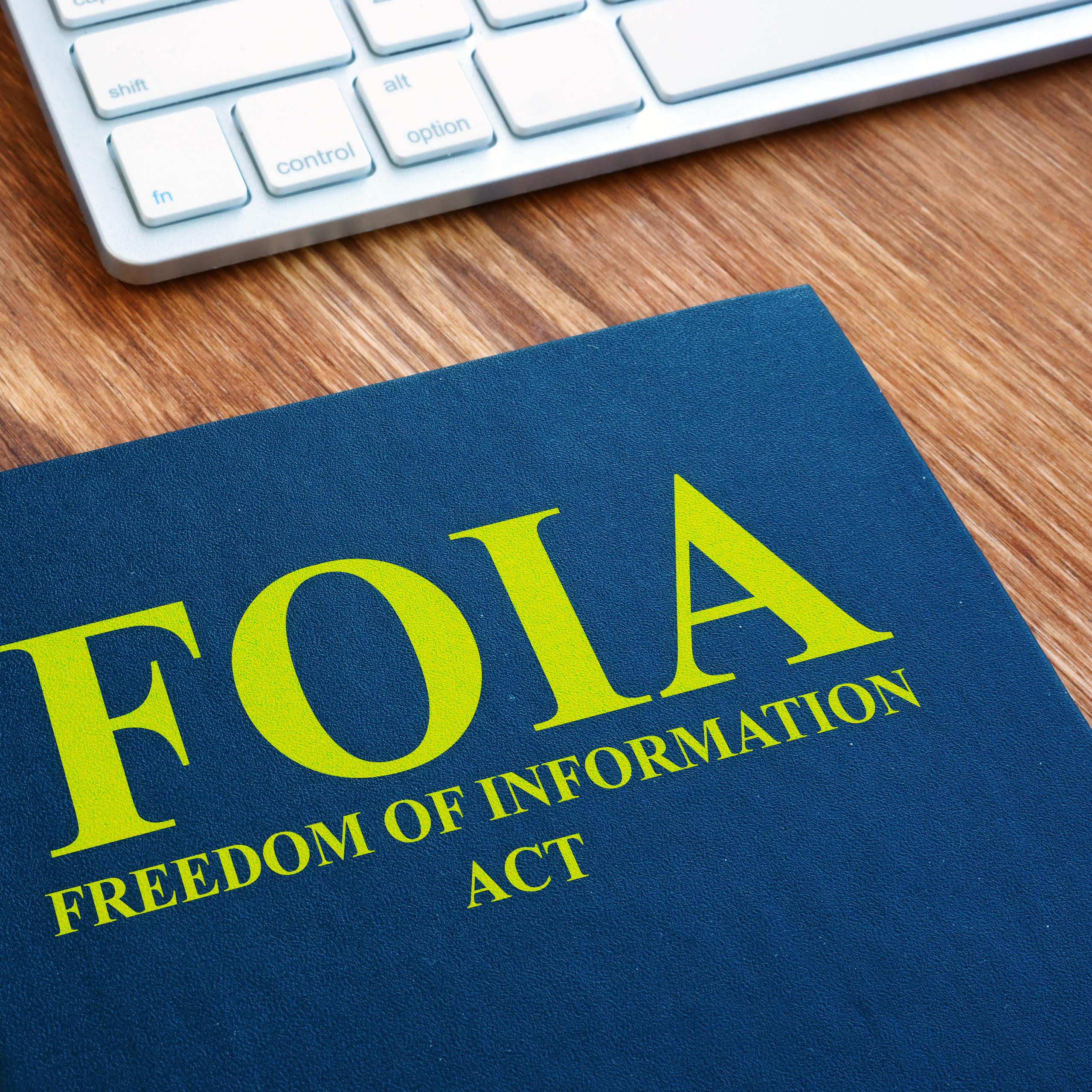 A blue book with a cover that says FOIA Freedom of Information Act lying on a desk