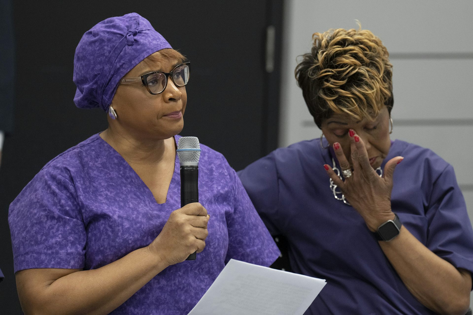 Dos trabajadores de apoyo personal vestidos con pelos de lila.