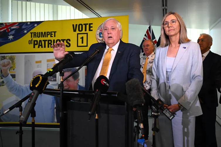 man and woman at lectern in front of yellow sign