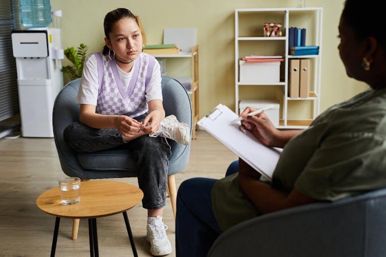The young girl who looks glamor talks to the therapist.
