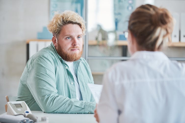 A man talks to a female doctor.