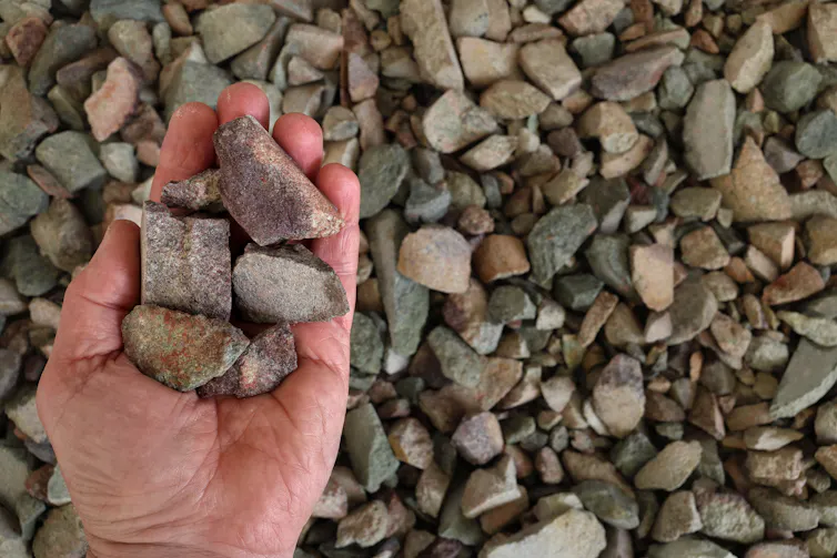 Rare earth (earths) ore held in open hand.