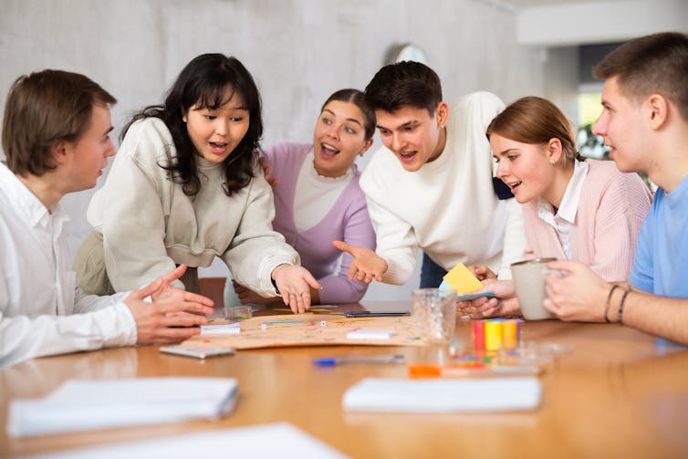 Students playing board game together