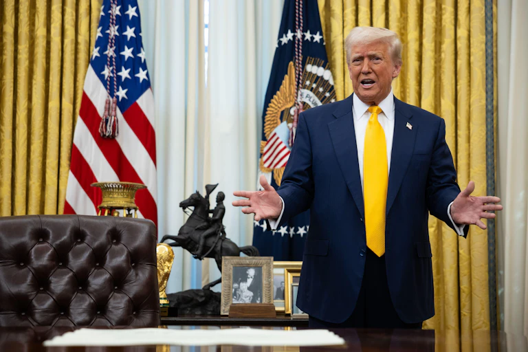 Donald Trump with his arms outstretched in the White House.