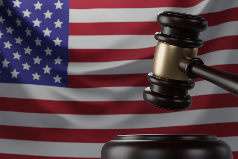 A US flag and a judge's gavel in front of it.