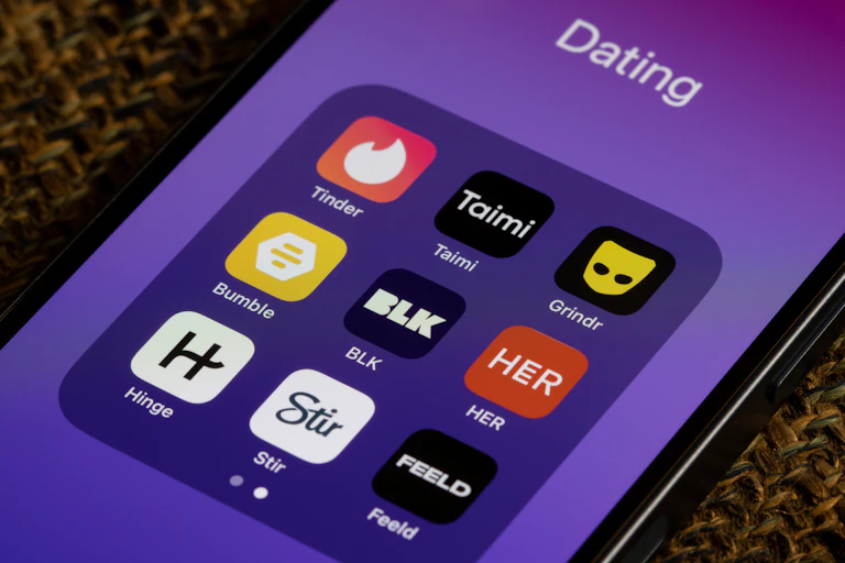 Logos for various dating apps on a smartphone