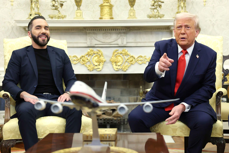 Salvadorean president Nayib Bukele sits in the Oval Office with the US president Donald Trump, who is pointing at the camera.