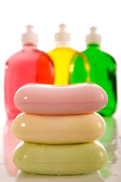 three colorful bars of soap in front of three colorful clear soap dispenser bottles