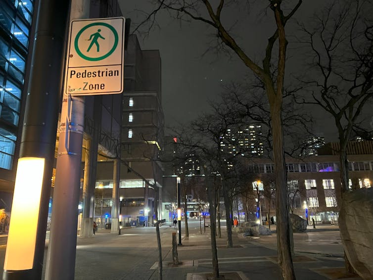 a street at night with signage clearly indicating a pedestrian zone