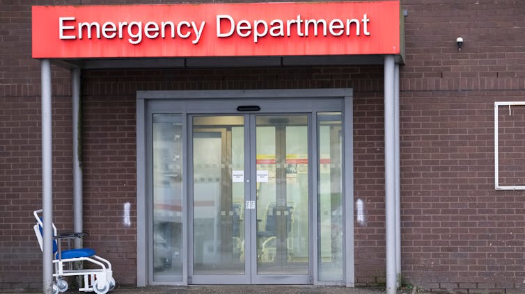 Hospitals have large environmental footprints – right here’s how they are able to be extra sustainable 1 hospital exterior, red emergency department sign, brick walls, empty wheelchair