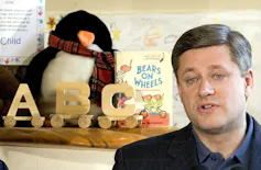 A man in a suit speaking next to toys.