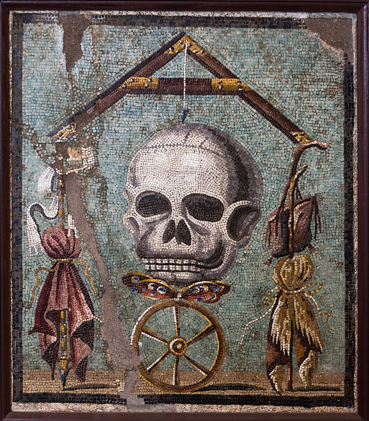 The mosaic features a large skull.