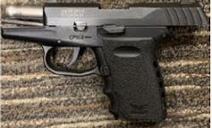 Una pistola tumbada en la alfombra