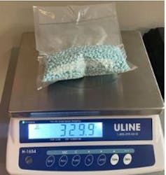 Bolsa que contiene muchas tabletas azules que se encuentran en la parte superior cromada de la escala digital