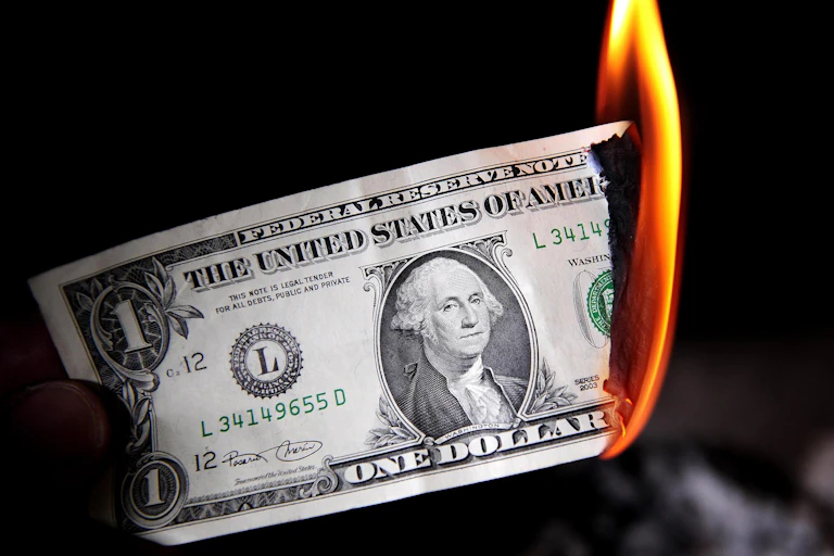 A dollar bill is shown burning.