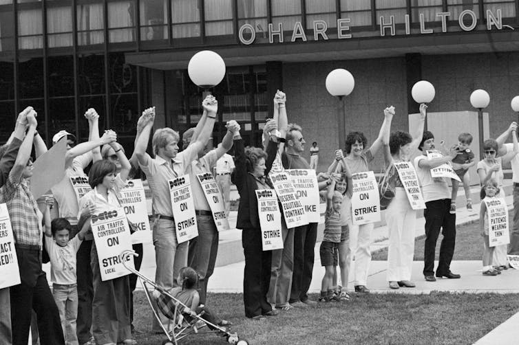 Protesters seen in a black-and-white photo with their arms aloft.
