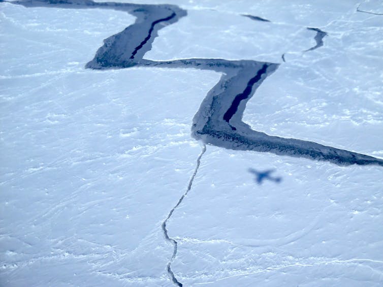 Aerial photo of a large zigzagging crack in sea ice.