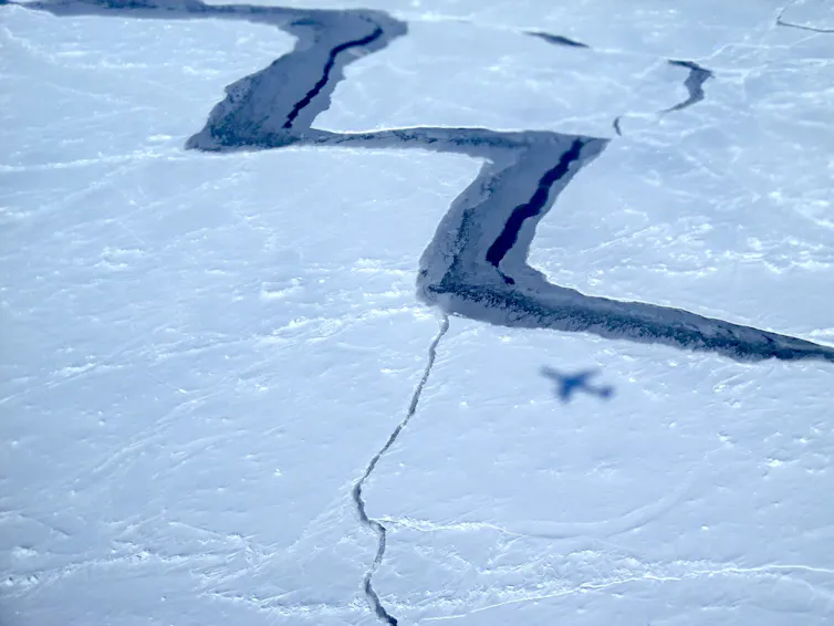 Aerial photo of a large zigzagging crack in sea ice.