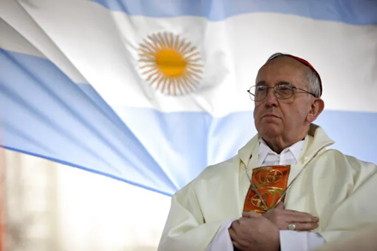 Bergoglio in front of the Argentinian flag.