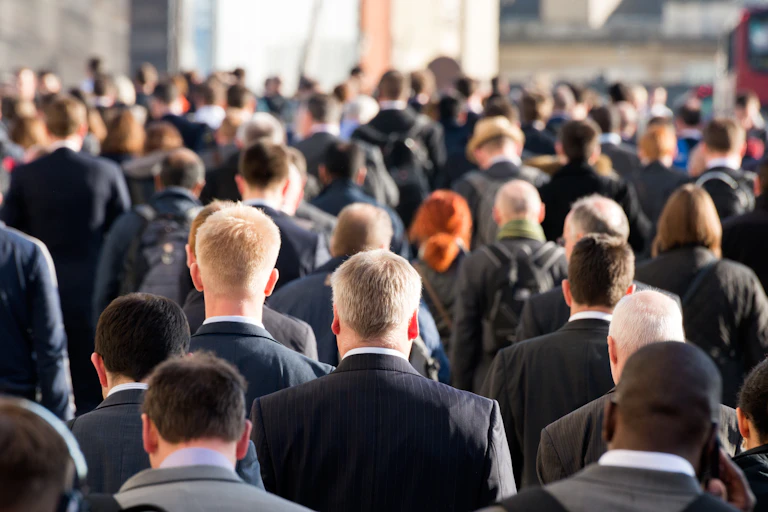 View from behind of a crowd of men walking on a busy street