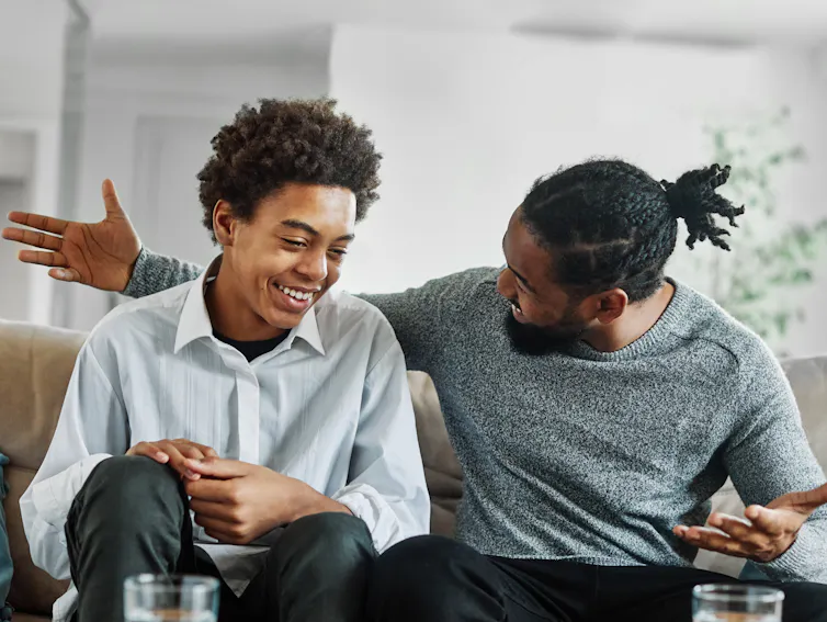 Man and teenager talking and smiling