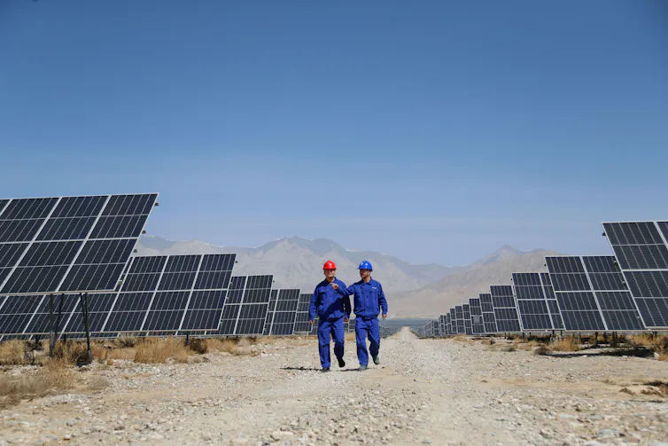 People walk through dusty solar farm