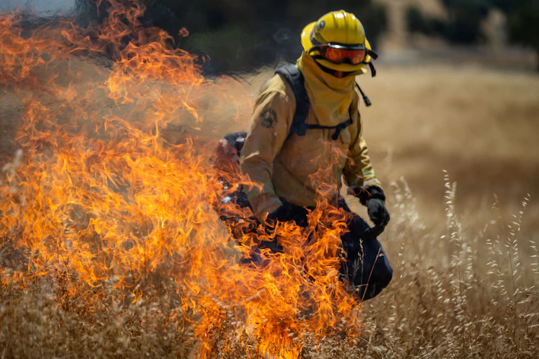 A Marin County firefighter uses a drip torch during a controlled burn training on June 21, 2024, in San Rafael, California