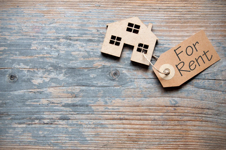wooden house with rental tag lying on a wood table