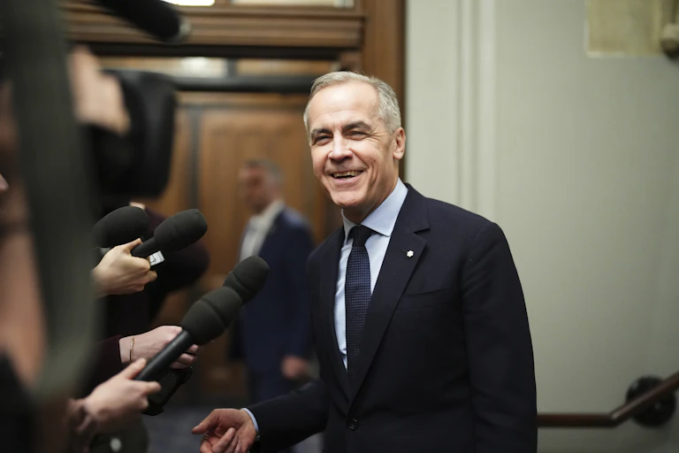 A man in a suit smiles at the camera