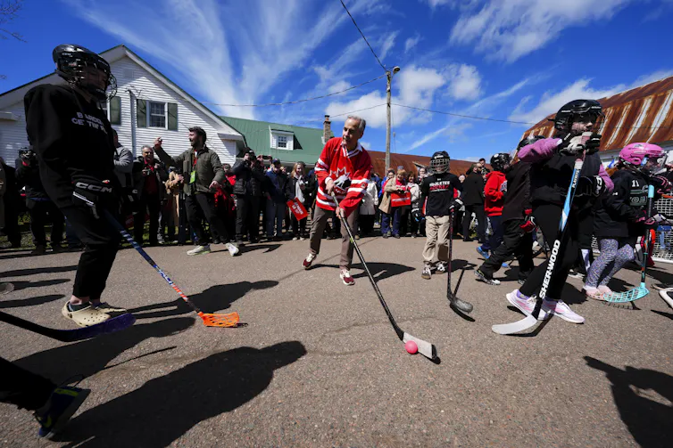 A group of politicians wearing ice hockey jerseys pose for a photo