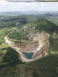 Aerial photo of a mined-out area in the side of a hill.