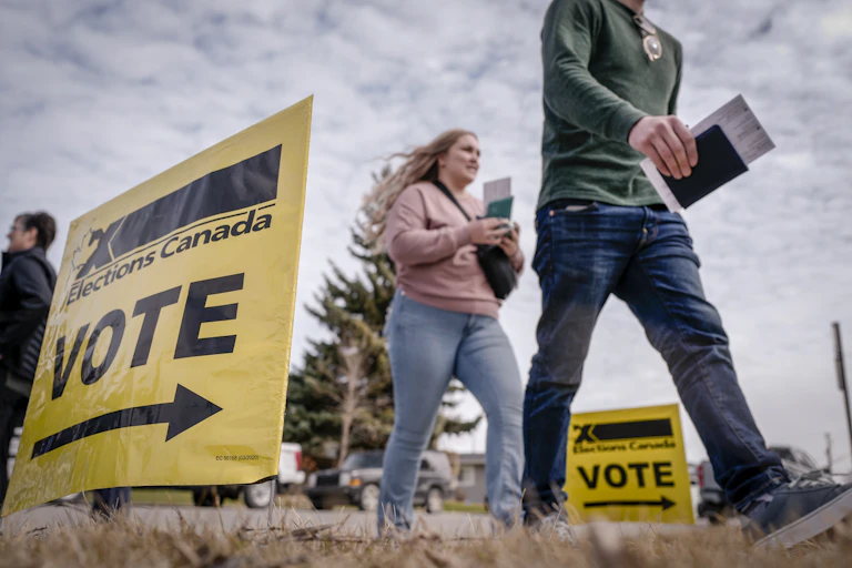 A vote sign as young people stride past.