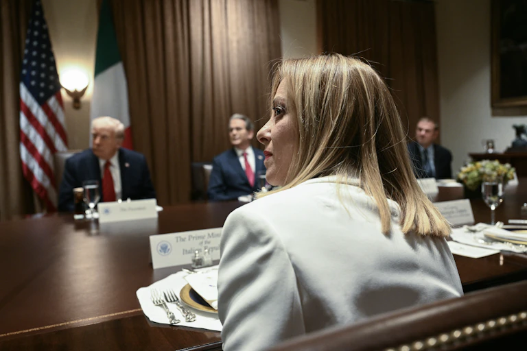 A woman sits at a conference table.