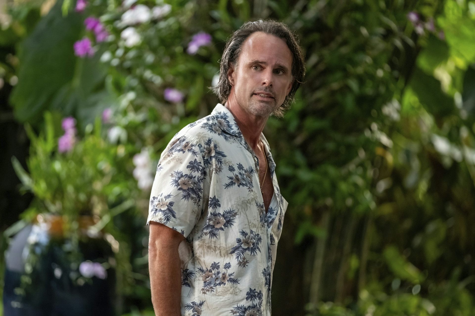 El hombre de la camisa hawaiana con una cara brillante.