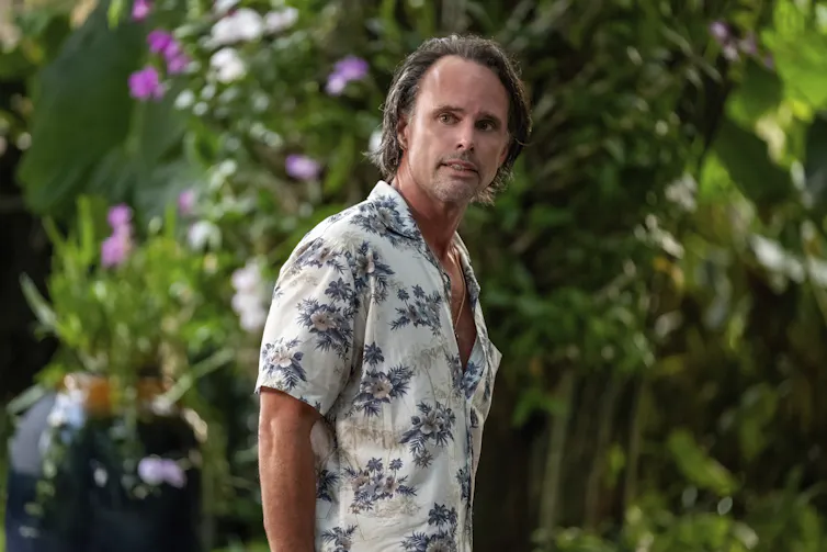 A man in Hawaiian shirt with a gleaming face.