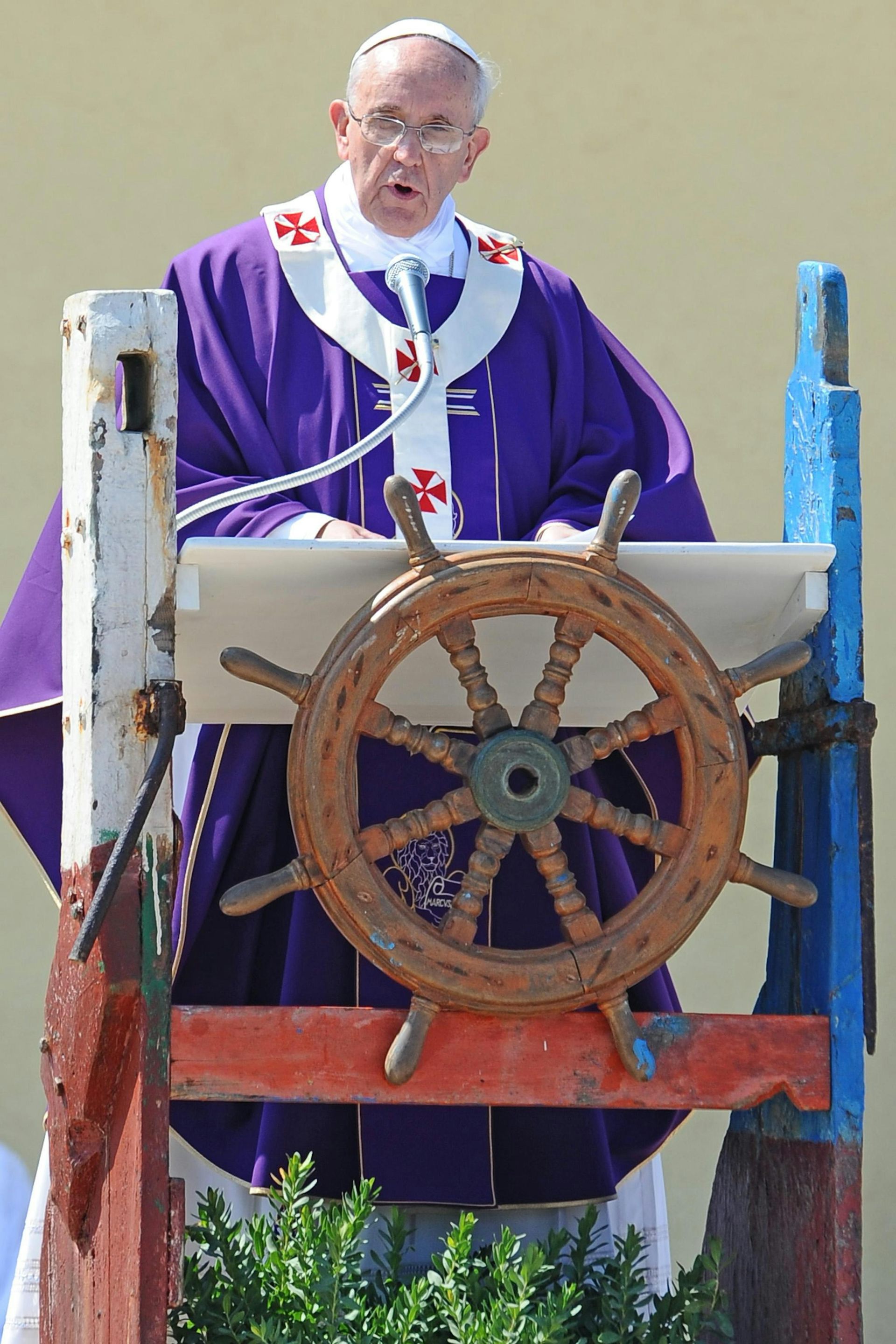 Pope Francis I delivers a speech while standing at a lectern shaped as a ship's helm.