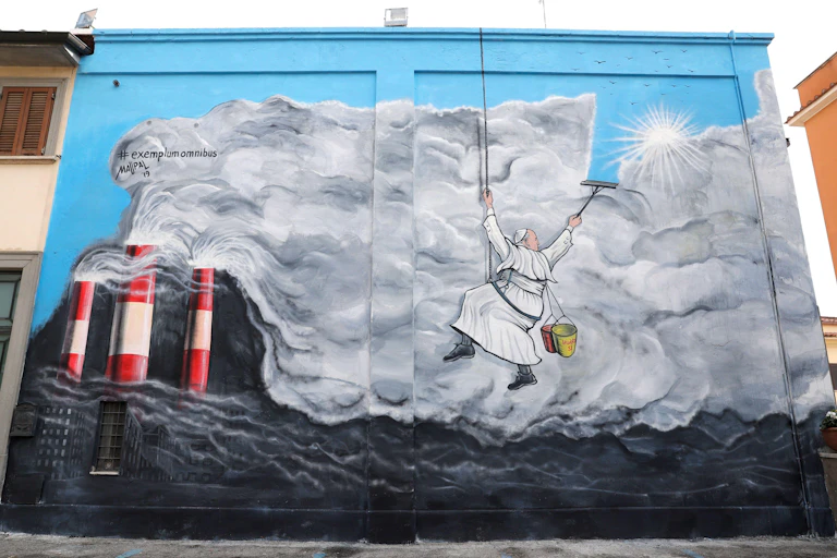 Mural of Pope Francis cleaning pollution from the sky