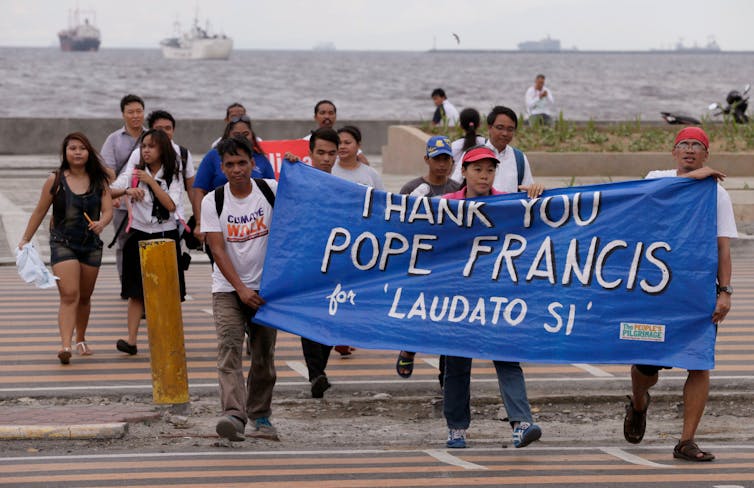 How Pope Francis turned into a local weather trade influencer 1 People hold 'Thank you pope francis, Laudato Si' banner