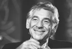 A man smiling and gesturing.