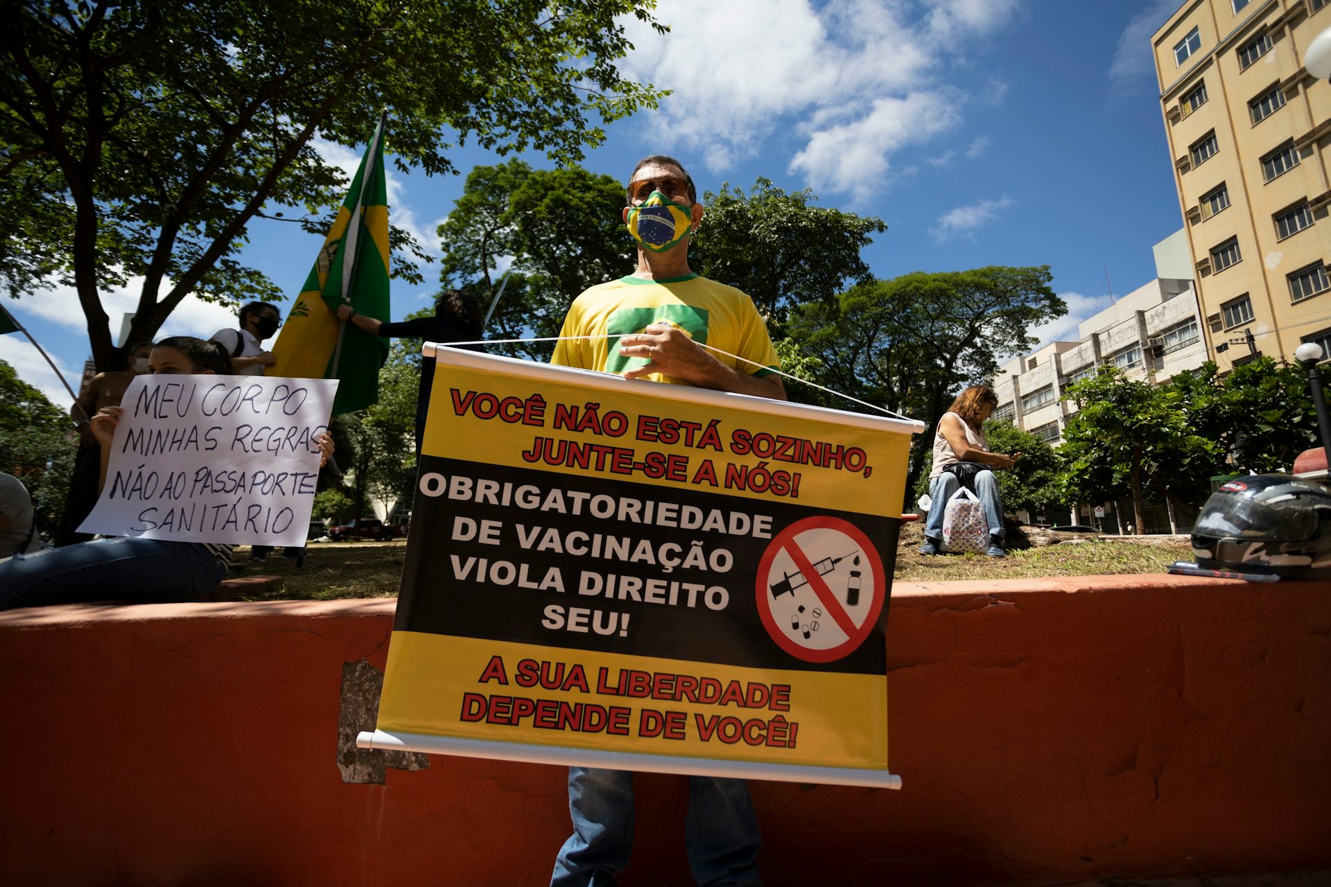 Manifestante segurando cartaz contra a vacinação no Brasil.