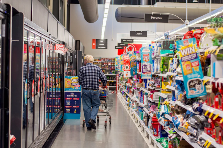 An old man surveying frozen food aisle at Coles Supermarket