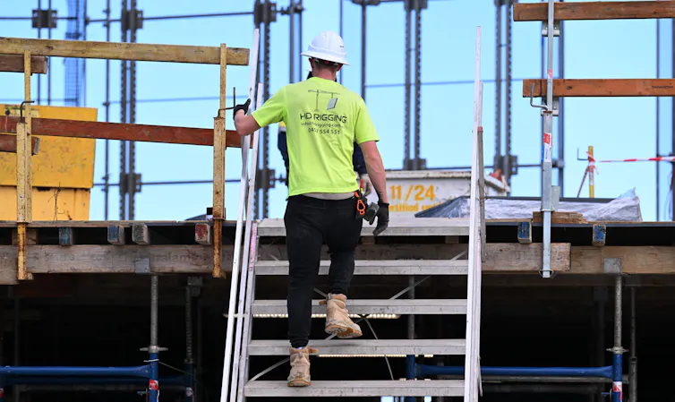 A worker at construction works on a building site for apartments