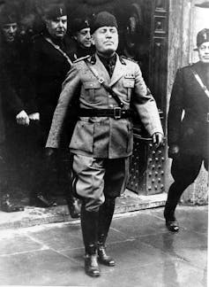 Benito Mussolini marches out into the rain during the 2,698th anniversary of the birth of Rome, Italy, on April 21, 1936