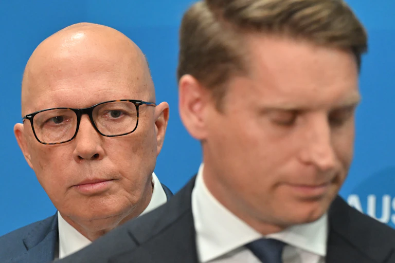 Peter Dutton standing behind the shoulder of Andrew Hastie.