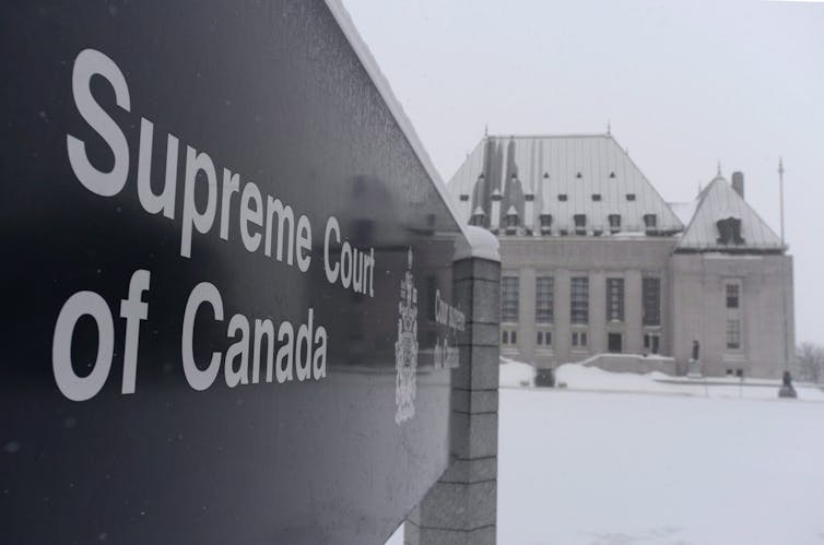 Firme leyendo la Corte Suprema en Canadá a la vanguardia con el edificio de la corte en invierno