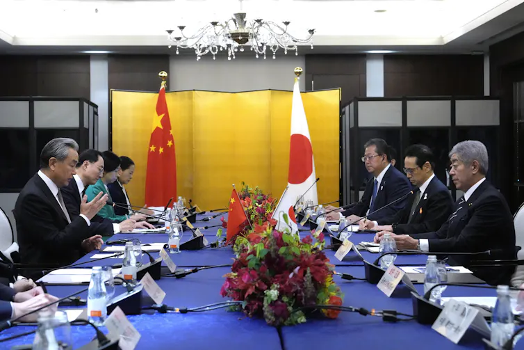 Takeshi Iwaya and Wang Yi sat across a table during a meeting.