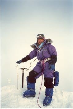 Dressed in purple, Tabei smiles, surrounded by all white ice and snow